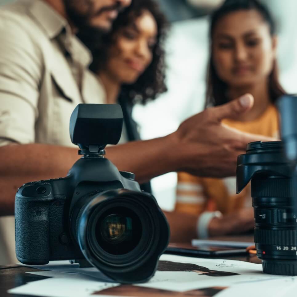 Image showing a close up of a camera with photographers talking in the background